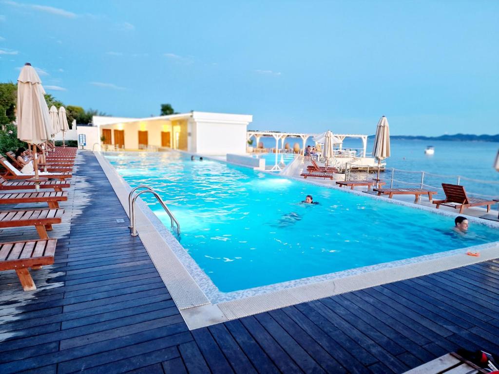 una piscina con gente nadando en el agua en Residence-Apartment-Giuliano-Punta Skala, en Petrcane