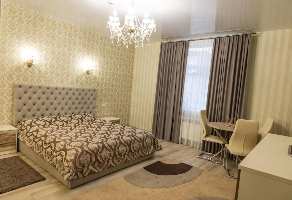 a bedroom with a bed and a dining room at Готельно-банний комплекс Otelnov in Poltava