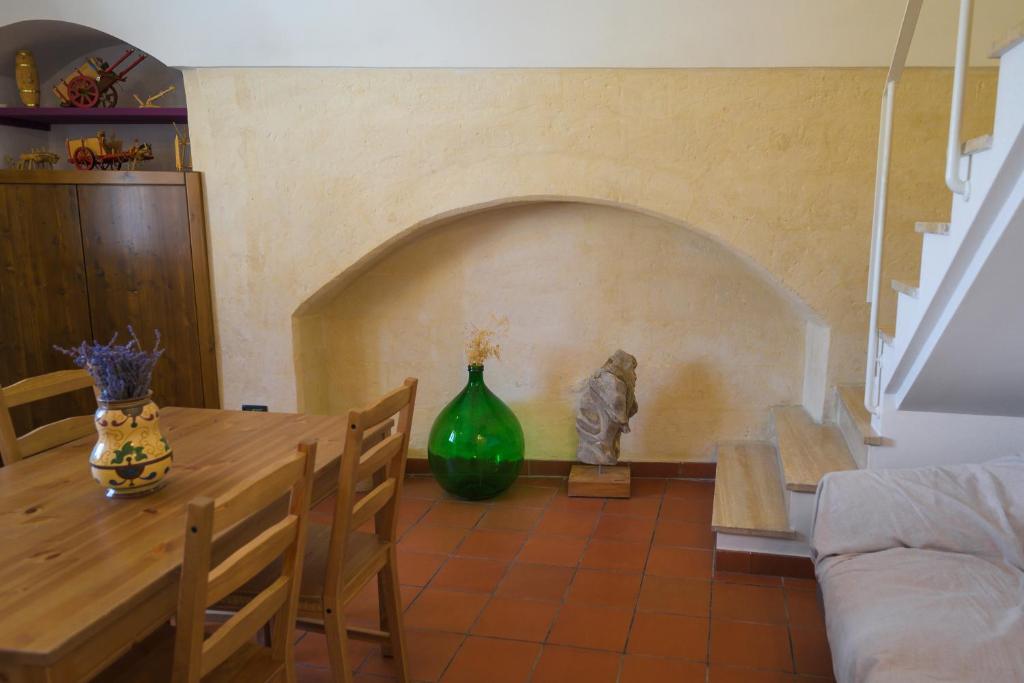 a dining room with a table and a green vase at The View Matera in Matera