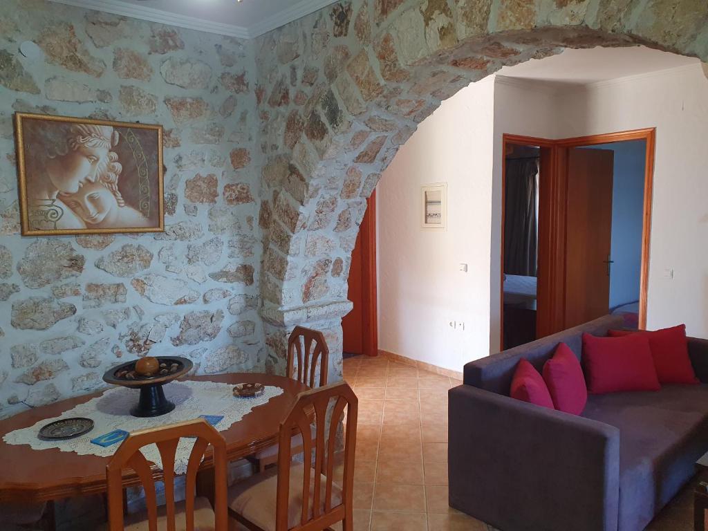 a living room with a table and a couch at Nireas : Stone Villa in Zakynthos