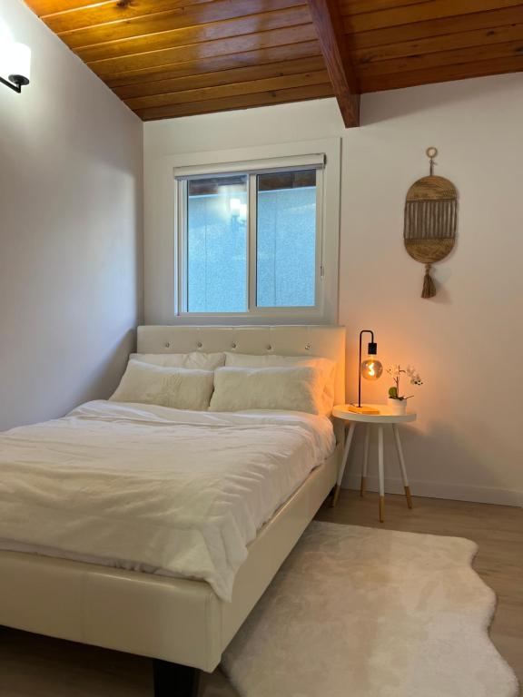 Un dormitorio blanco con una cama grande y una mesa en ! 5 Bed Beautiful Home with Fenced Yard & Hammock! WEM - Foosball Table - WiFi - Fireplace - Long Stay, en Edmonton