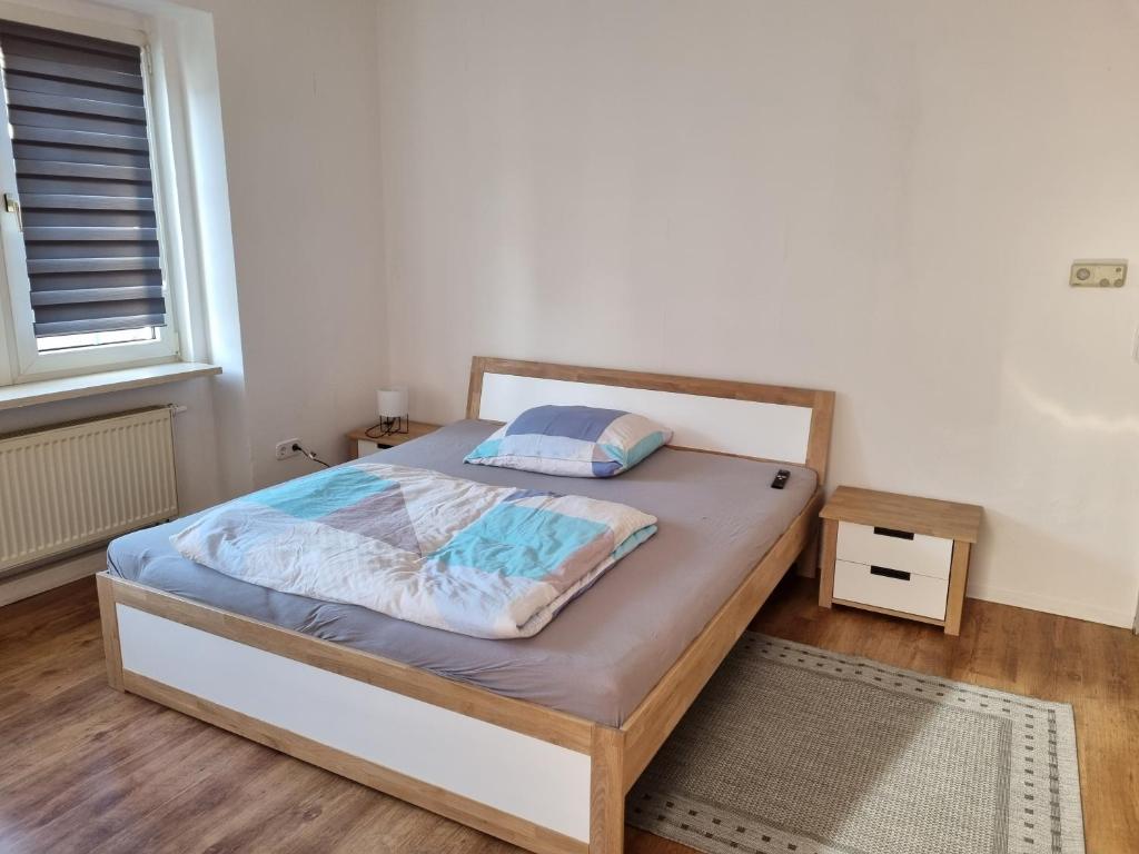 - une chambre avec un lit doté d'un cadre en bois dans l'établissement MacFeWo - Komplette Ferienwohnung im Stadtkern von Mayen, à Mayen