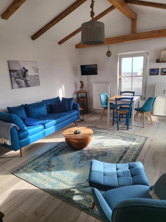 a living room with a blue couch and a table at Crampas 2 in Sassnitz