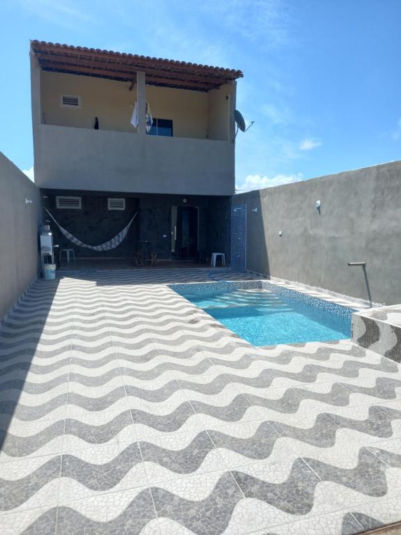 uma casa com piscina em frente a uma casa em Casa de praia majorlandia em Majorlândia