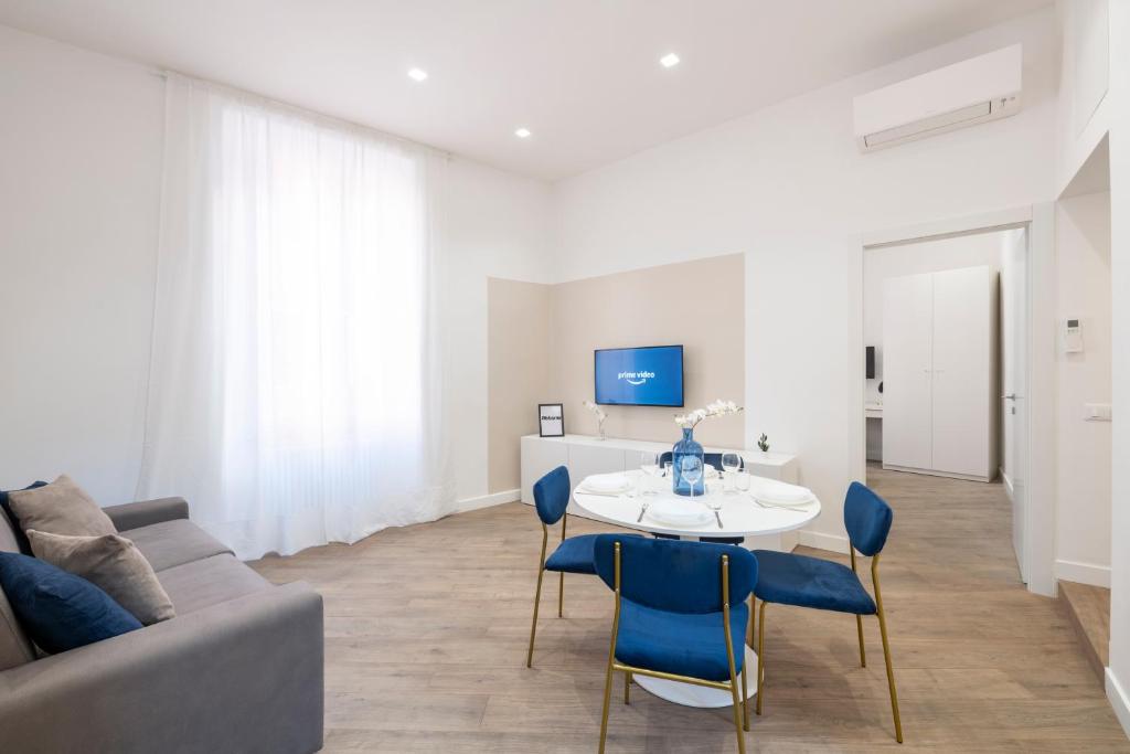 een woonkamer met een bank en een tafel en stoelen bij White Flat Cross in Rome