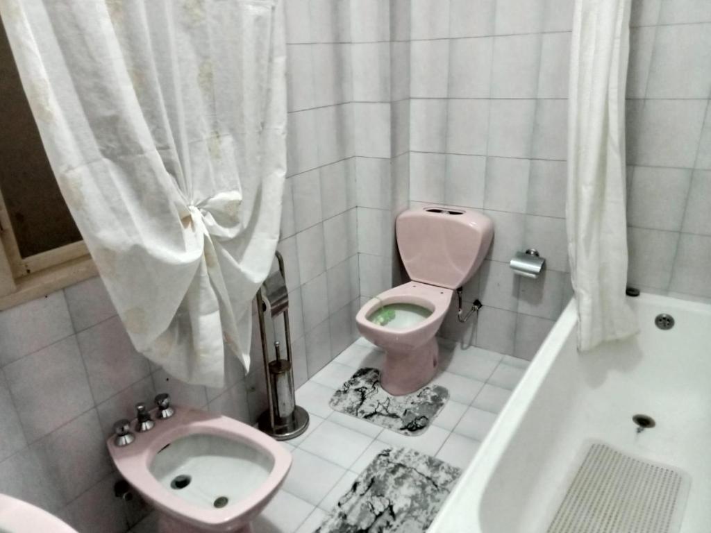 a bathroom with a pink toilet and a bath tub at La Casa del Sole in Giarre