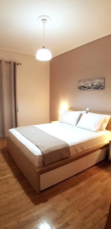 um quarto com uma grande cama branca num quarto em Modern home, 6' from the Metro em Atenas