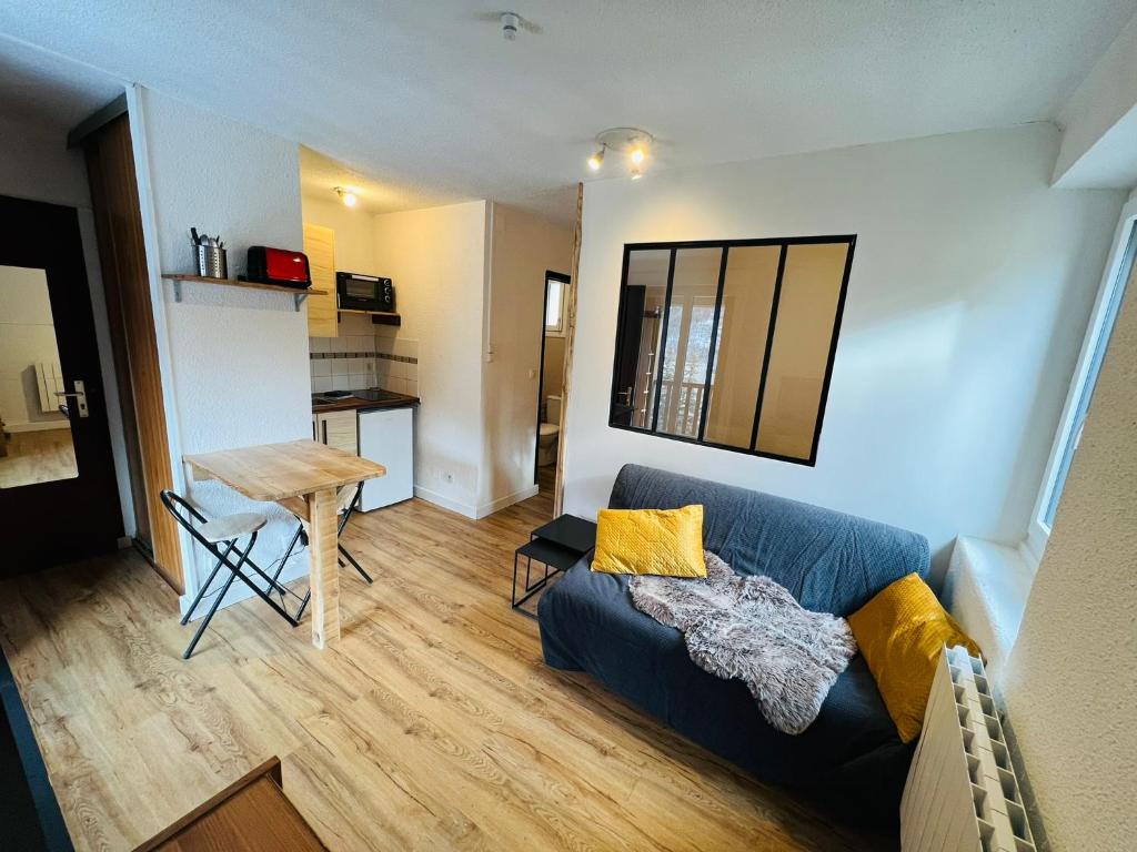 a living room with a couch and a table at Studio Montagne - Plein Soleil et Terrasse in Briançon