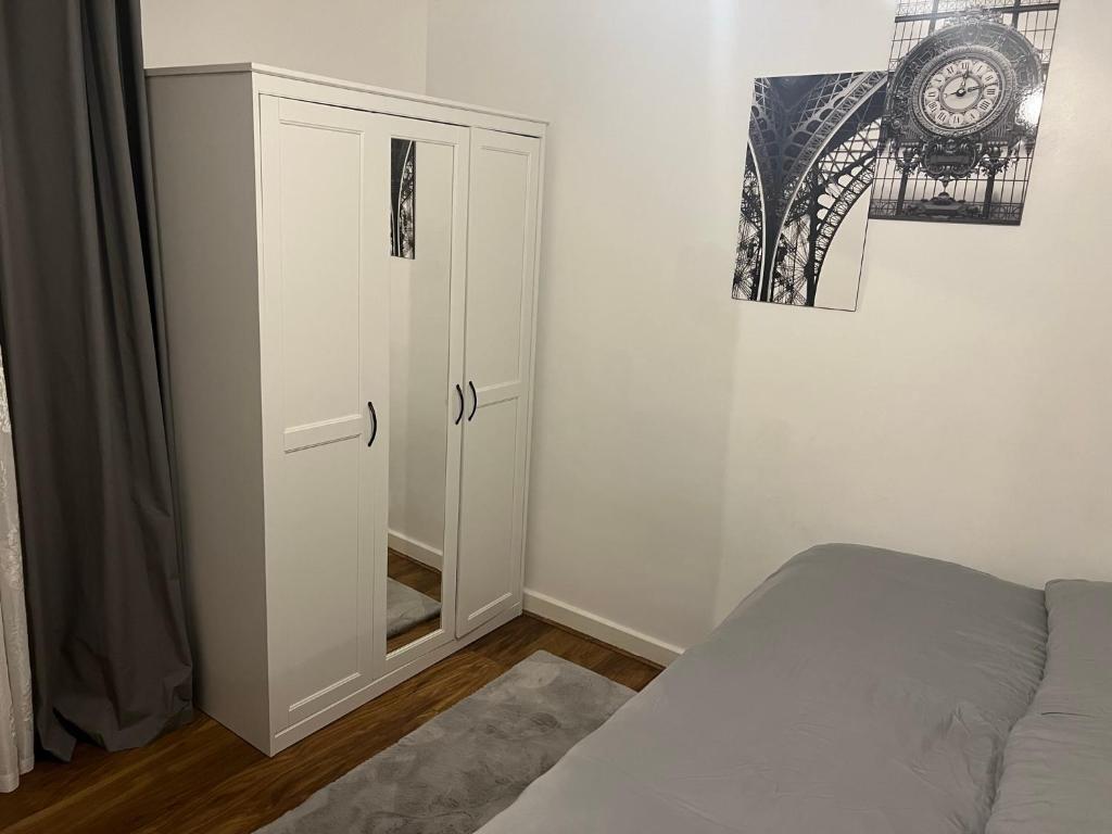 1 dormitorio con armario blanco y cama en Accu care apartment, en Londres