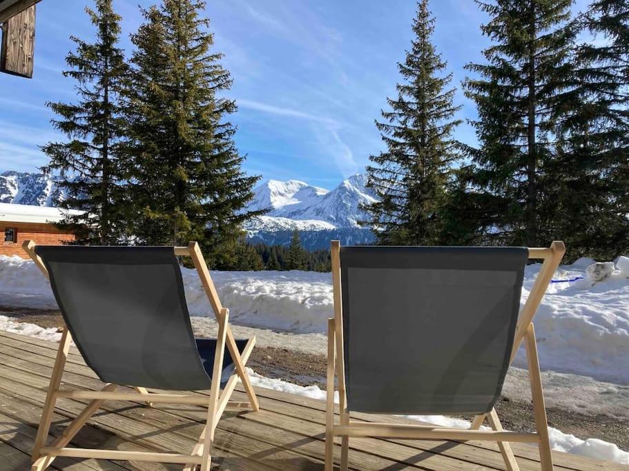 two chairs sitting on a deck in the snow at Charmant T2 proche des pistes superbe vue in Chamrousse