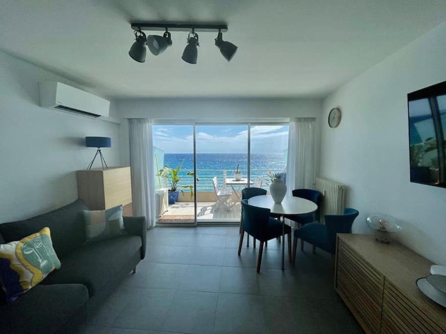 uma sala de estar com uma mesa e vista para o oceano em Sea view apartment, huge terrace on the 4th floor em Menton