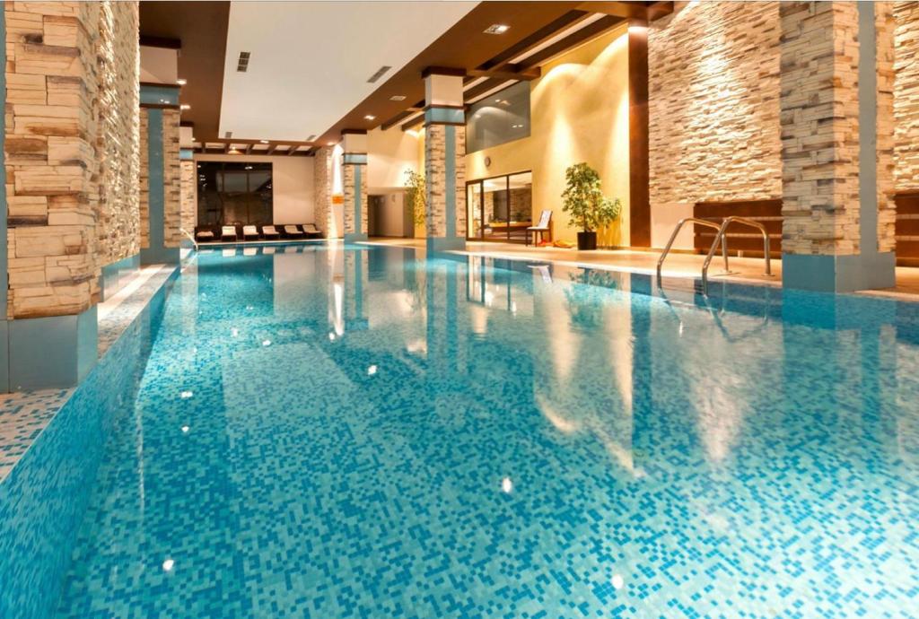 a swimming pool in a hotel with blue water at Apartaments by Zenit in Terra Complex B16 & C18 near Bansko in Razlog