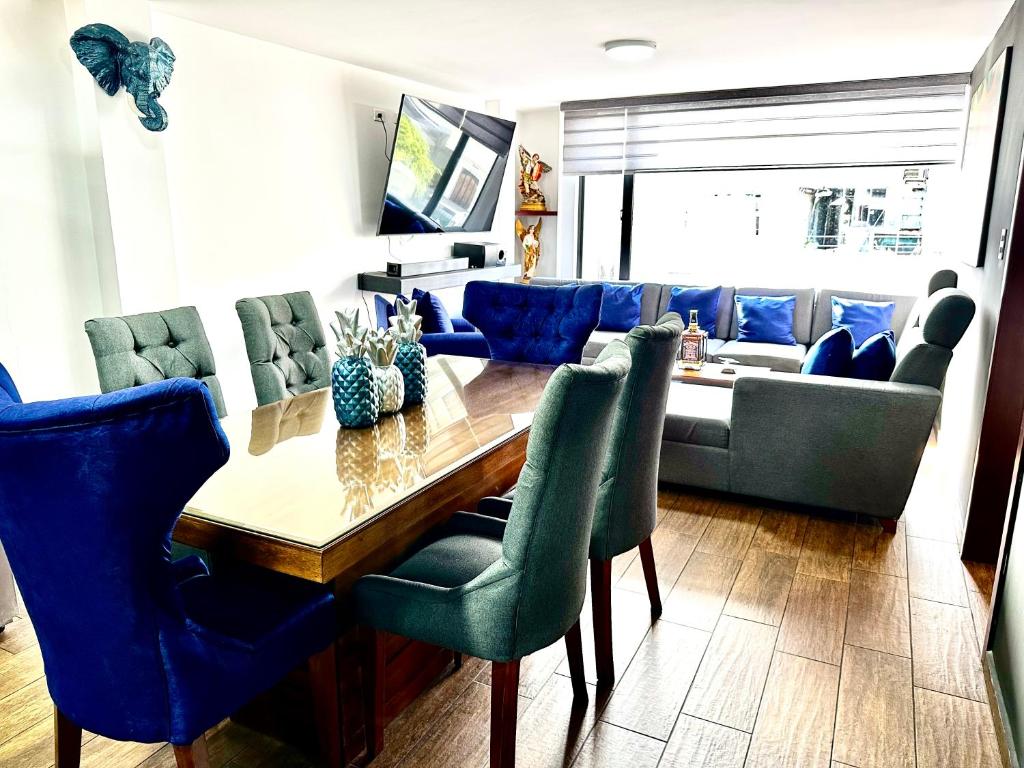 sala de estar con mesa y sillas azules en Hermoso departamento con jacuzzi privado, en Quito