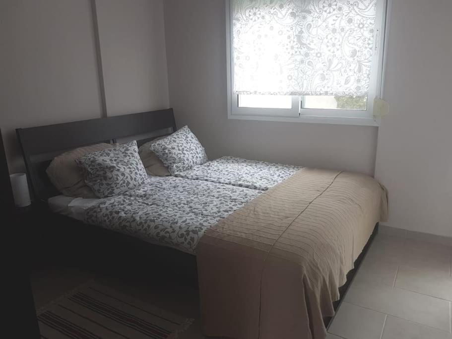 małe łóżko w sypialni z oknem w obiekcie Квартира Халкидики Флогита / Ferienwohnung Chalkidiki Griechenland w mieście Flogita