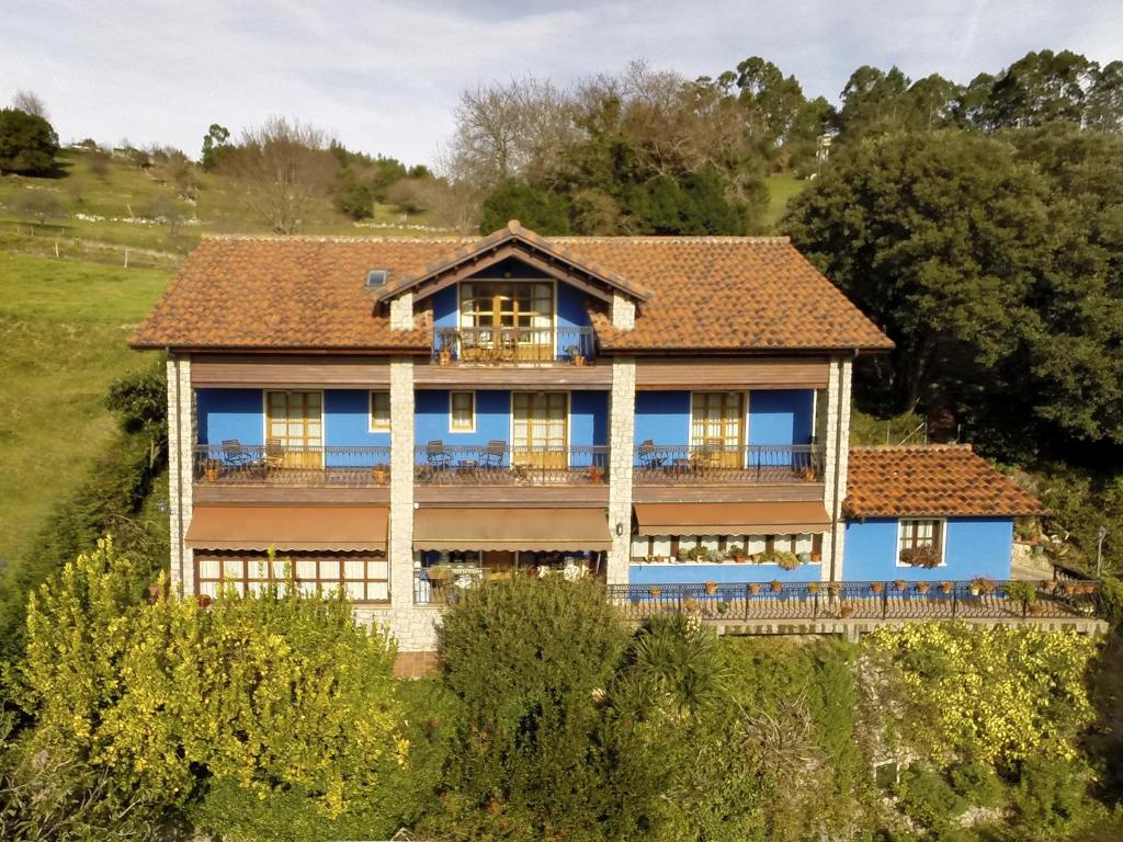 a large blue house with a roof at Apartamentos Rurales El Corberu in Ardines