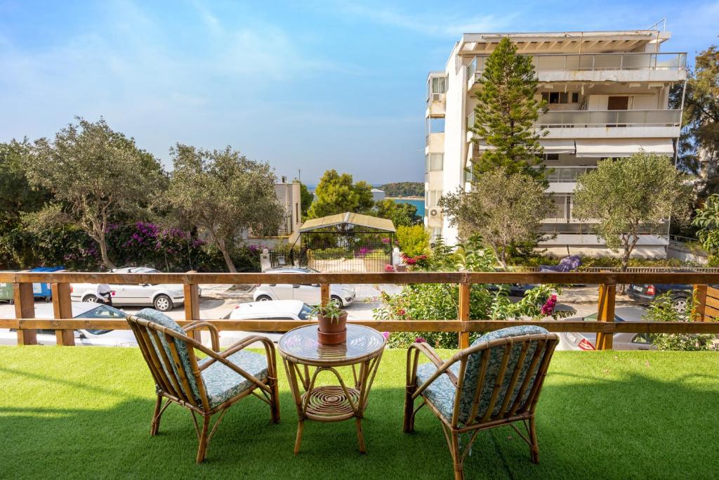 a patio with two chairs and a table on grass at Beachside Bungalows in Athens