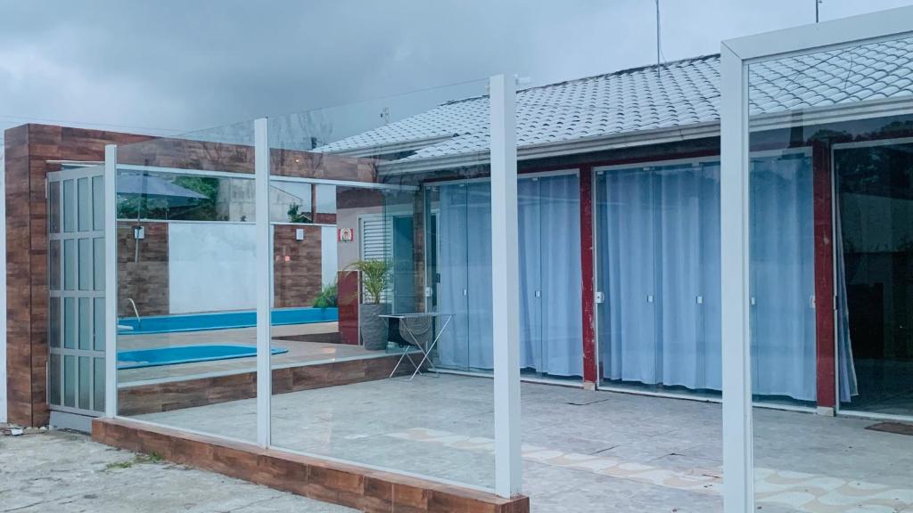 a glass facade of a building with a patio at Casa c piscina matinhos S Etiene in Matinhos