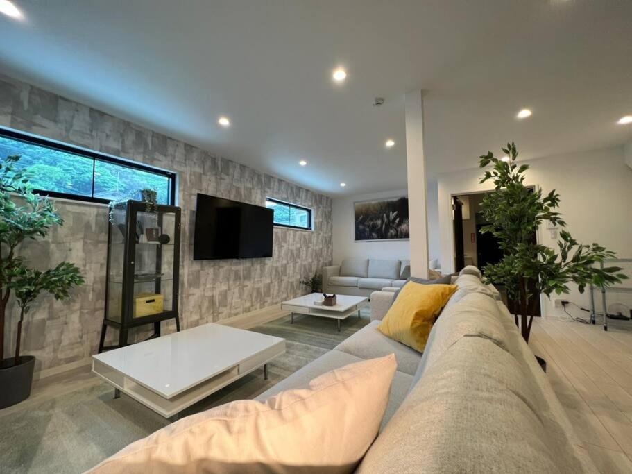 a living room with a couch and a tv at Ms. White Beach Resort in Kanayama