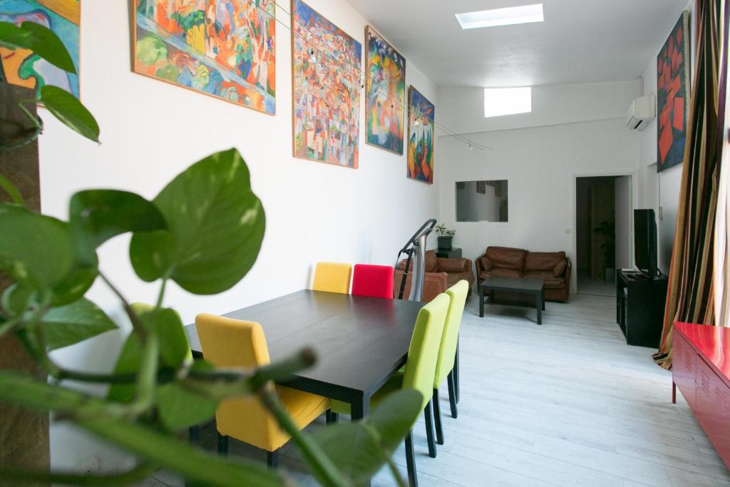 a dining room with a table and yellow chairs at Paris East Side Lodge in Pantin