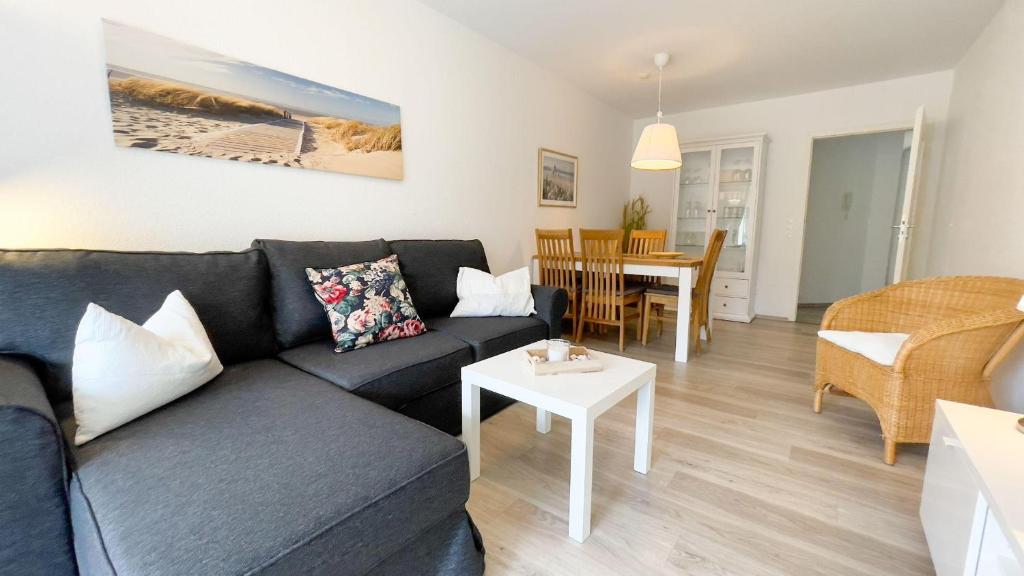 sala de estar con sofá y mesa en Strandhaus-Nordseebrandung-Fewo-B2-1 en Cuxhaven