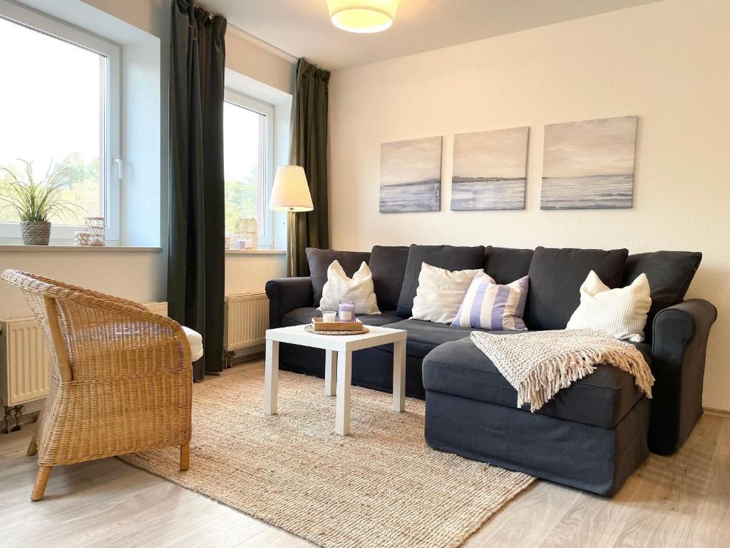 un soggiorno con divano blu e tavolo di Strandhaus-Nordseebrandung-Fewo-A3-2 a Cuxhaven