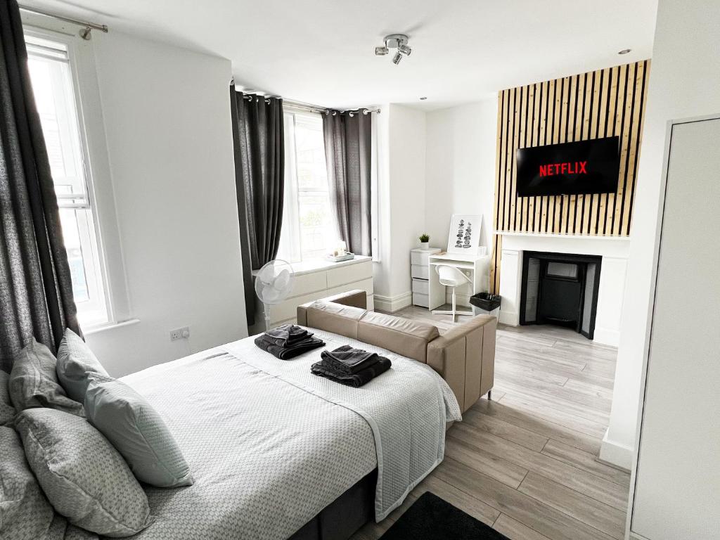 a white bedroom with a bed and a fireplace at Minet Gardens House - Suite 6 in London