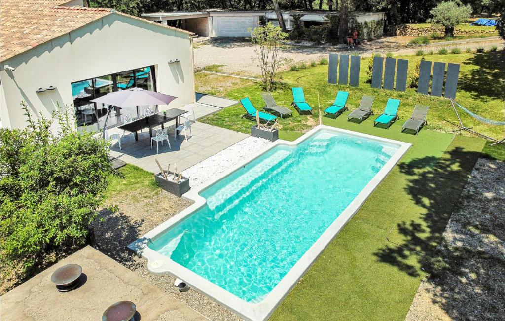 uma vista superior para uma piscina com cadeiras e uma mesa em 4 Bedroom Stunning Home In Rognes em Rognes