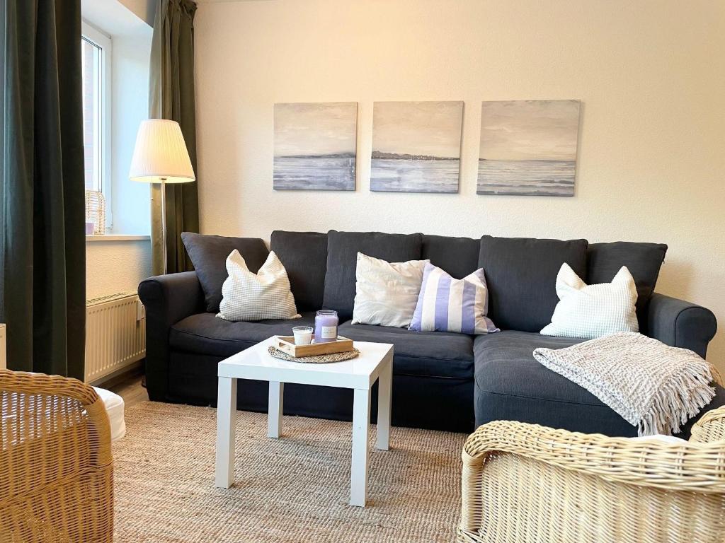 ein Wohnzimmer mit einem Sofa und einem Tisch in der Unterkunft Strandhaus Nordseebrandung Fewo A1.2 in Cuxhaven
