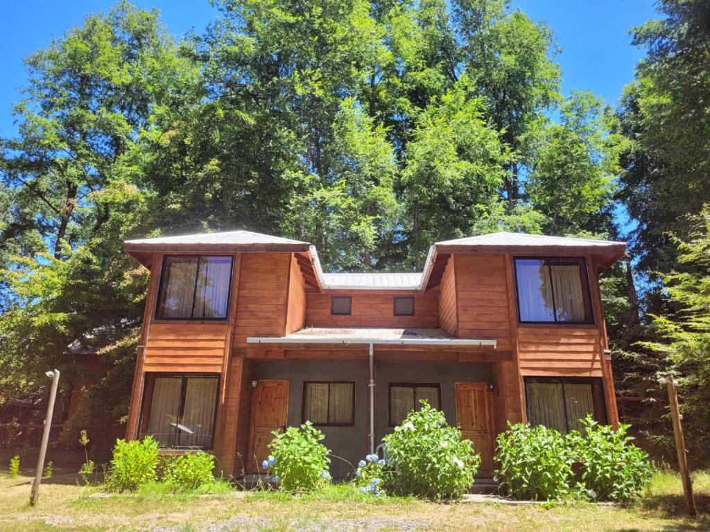 a wooden house with trees in the background at Townhouse Millatray in Caburgua