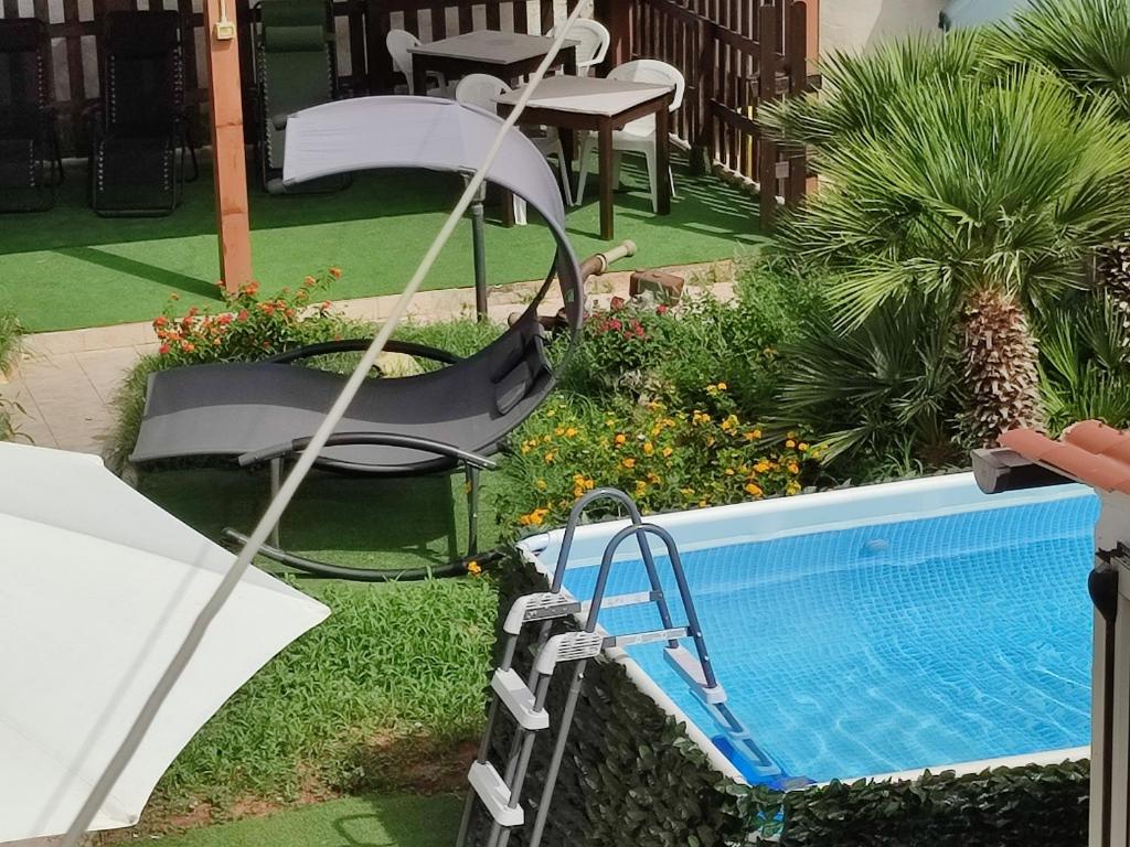 - une piscine avec une balançoire et une chaise près de la piscine dans l'établissement Le Due Palme, à Marsala