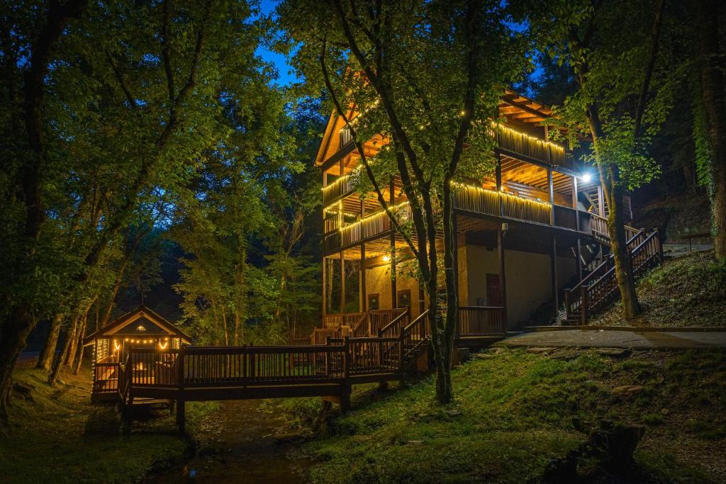 a house in the woods at night at Voted #1 Cabin in Smokys! Spa, Arcade, Private, Creek, King Beds in Sevierville