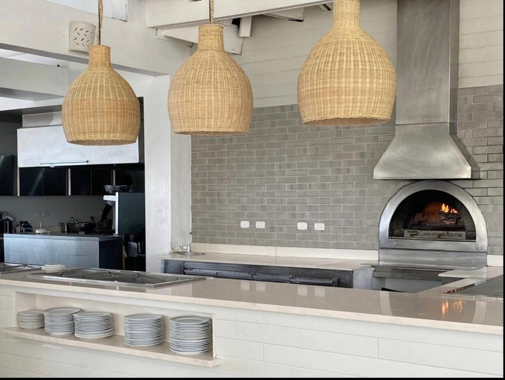 a kitchen with two pendant lights and a pizza oven at Paradise Suite Cadaqués in Bayahibe