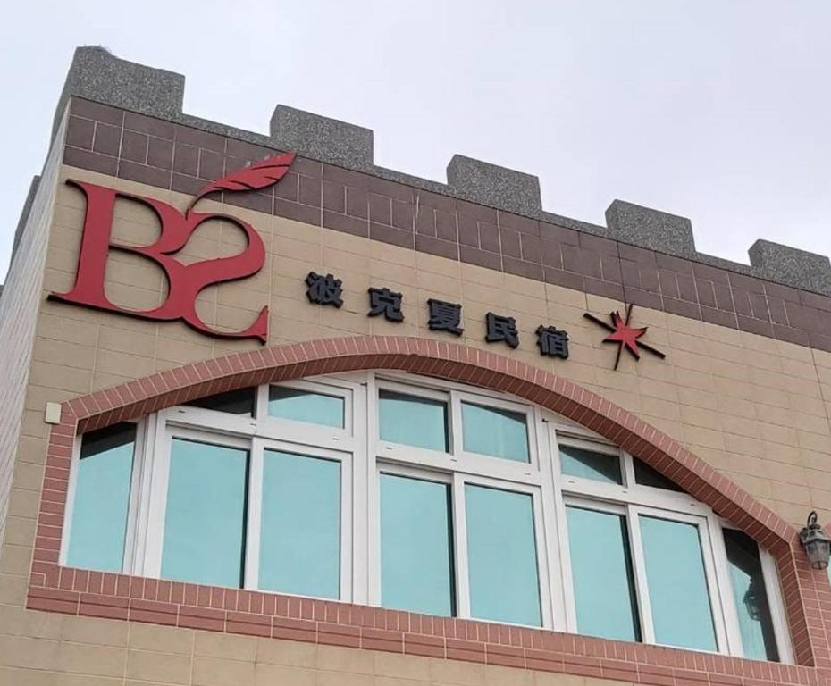a building with a sign on the top of it at Berkshire B&B in Qimei