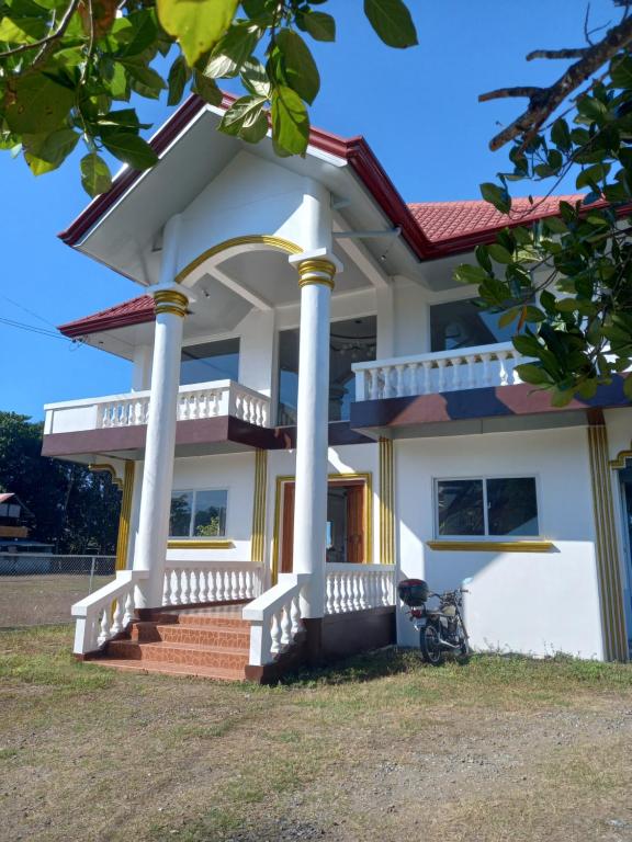 ein weißes Haus mit Säulen und einer Veranda in der Unterkunft Seven Waves Beachfront Vacation Home, Bauang La Union 