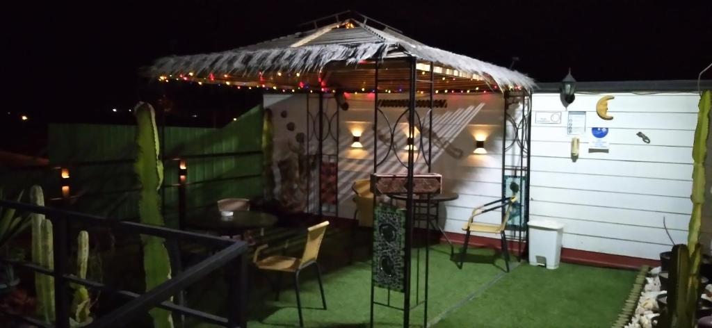 Apart Hotel Caldera - Room في كالديرا: شرفة مع طاولة وكراسي وأضواء