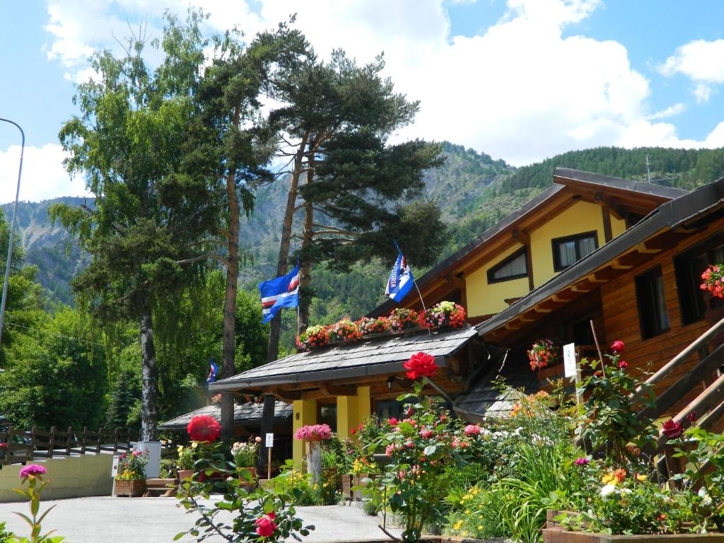 een gebouw met vlaggen en bloemen ervoor bij Hotel Cà Fiore in Bardonecchia