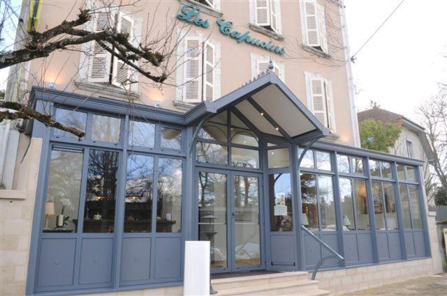 un edificio con una puerta azul y un edificio en Logis Hôtel Restaurant Les Capucins, en Avallon