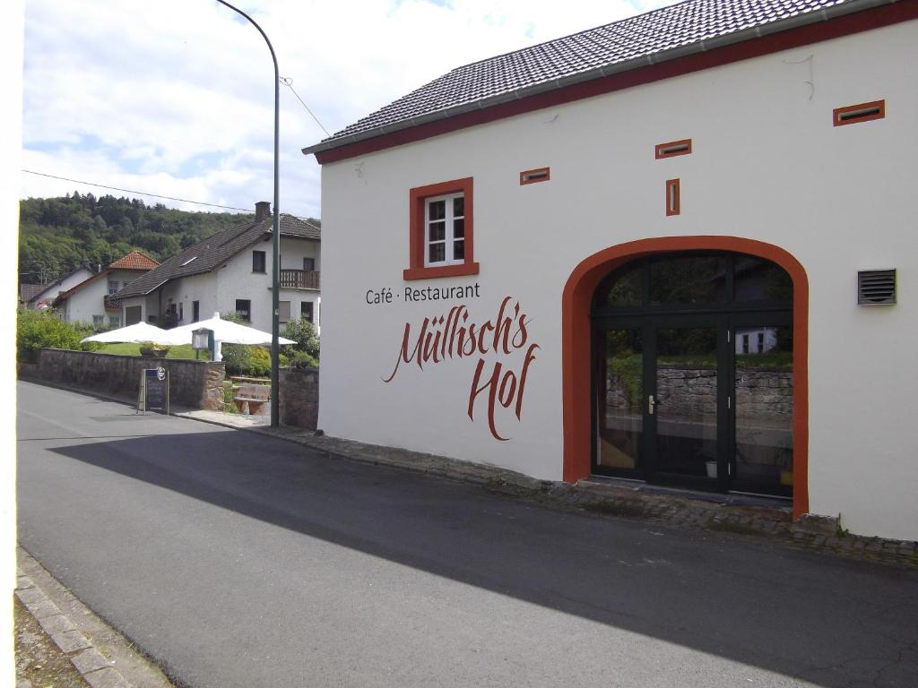a white building with a sign on the side of it at Müllisch's Hof Hotel in Dohm-Lammersdorf