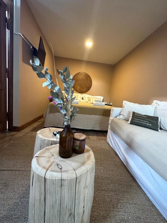 una habitación con 2 camas y una mesa con un jarrón con flores en Tanah Loft - en Villa Mercedes