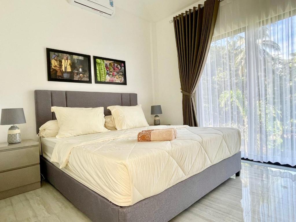 Postel nebo postele na pokoji v ubytování De Residence Pangandaran by Mabano Estates
