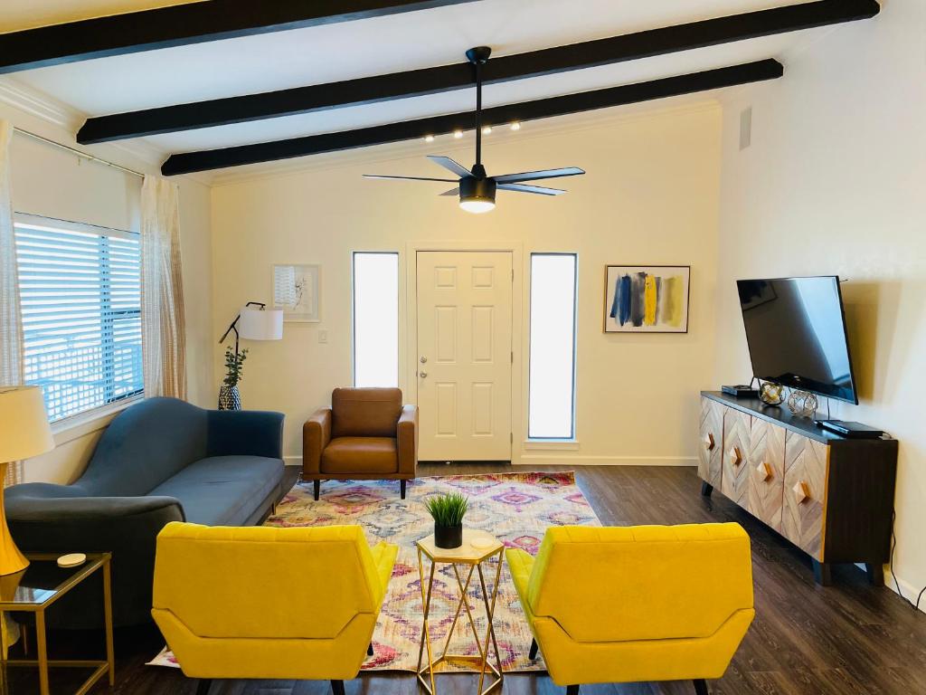 a living room with a blue couch and yellow chairs at Sandstone Ridge Apartments Remodeled 6 Bedroom 4 Bath in Oklahoma City