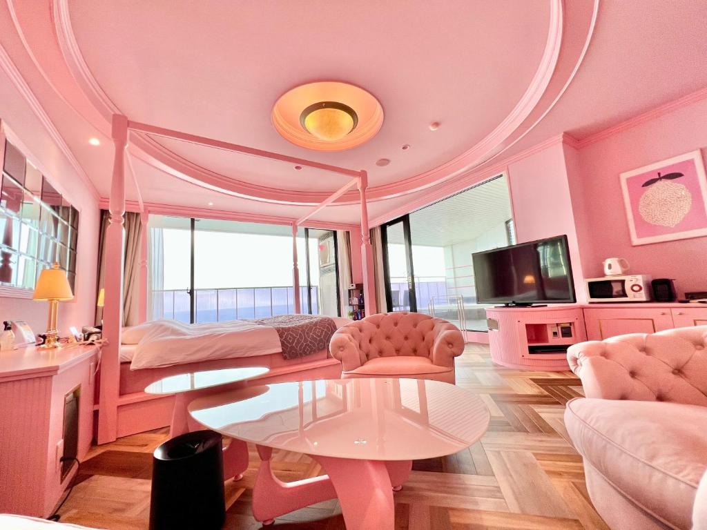 SKY Tower Sweet 4 Beppu, Resort Love Hotel في بيبو: غرفة وردية مع سرير وطاولة