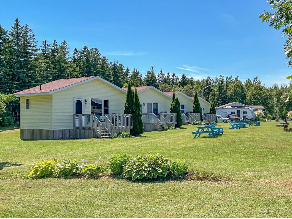 un grupo de casas en un patio con un parque en Baywatch Lighthouse Cottages & Motel, en Brackley Beach