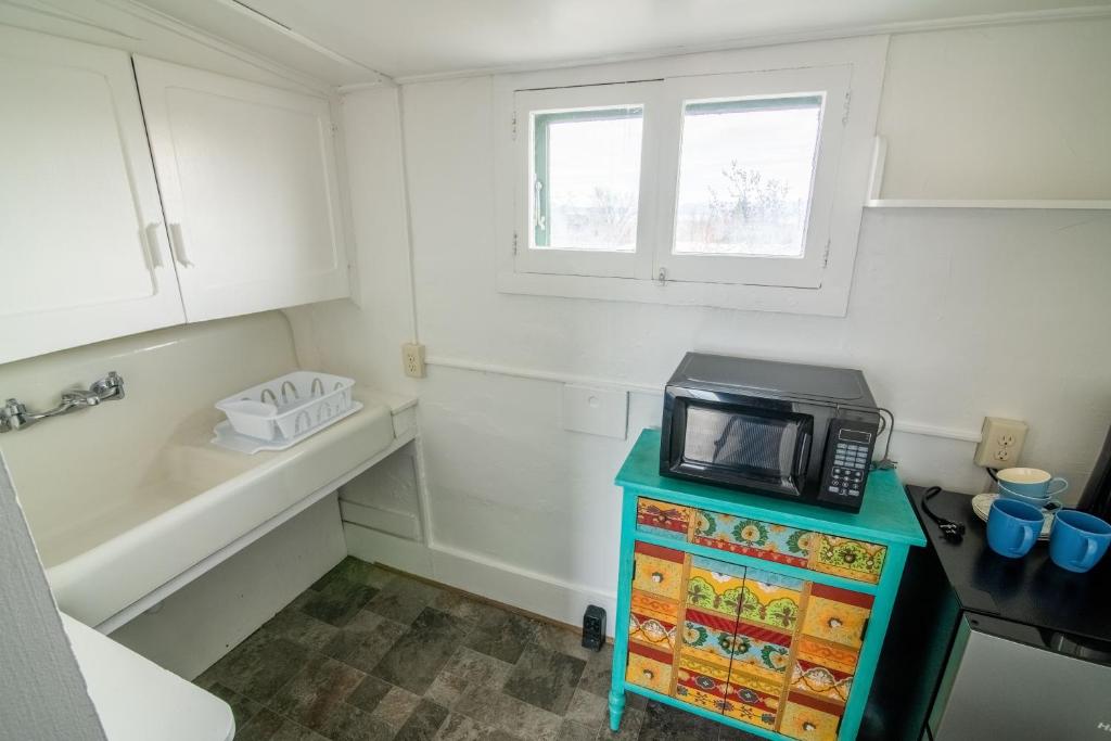 a small kitchen with a microwave on a table at Pope House - Hist. Mansion - The Wild(e) Suite in Helena