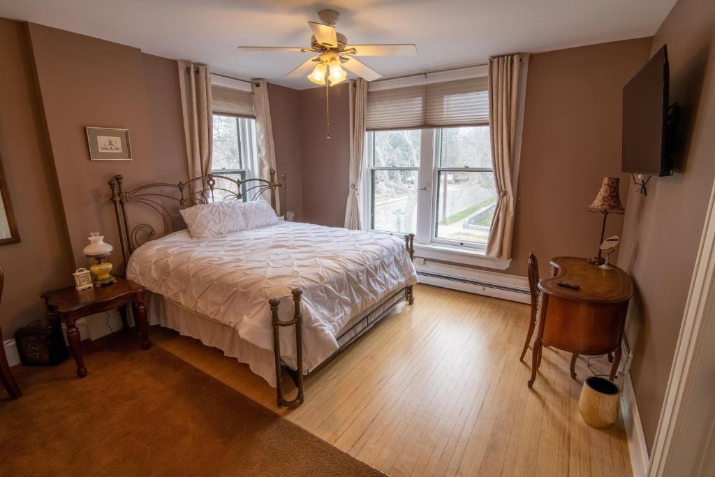 um quarto com uma cama, uma ventoinha de tecto e uma janela em Pope House - Hist. Mansion - The Gold Rush Suite em Helena