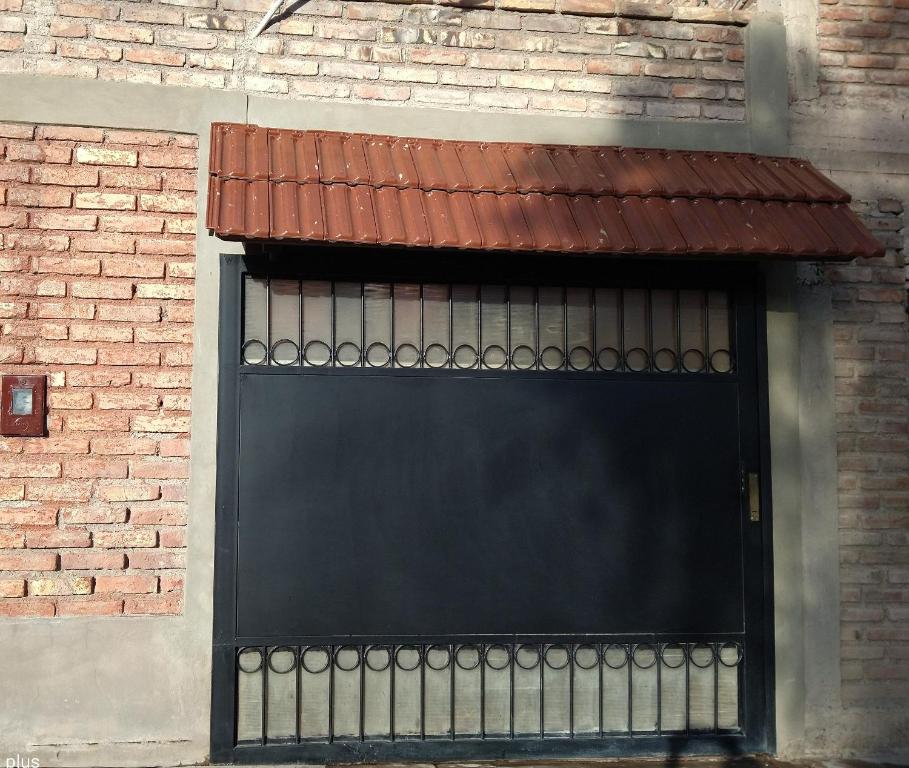una puerta de garaje negra en un edificio de ladrillo en Eris 1 en Godoy Cruz