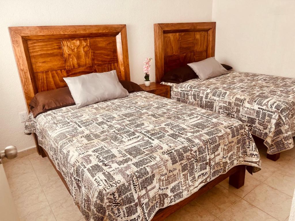 two beds in a room with two beds sidx sidx sidx at CASA HUELLAS EN LA ARENA in Ixtapa