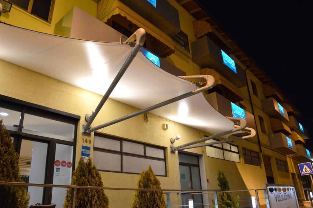 un grand objet blanc suspendu du côté d'un bâtiment dans l'établissement Valmarina, à Calenzano