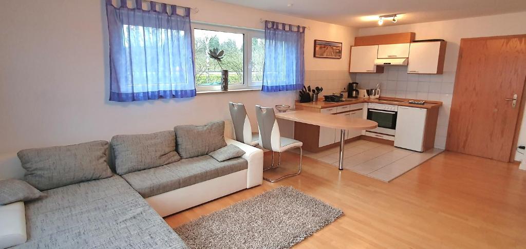 a living room with a couch and a table and a kitchen at Ferienwohnung für 5 Personen in Wasserburg in Wasserburg am Bodensee