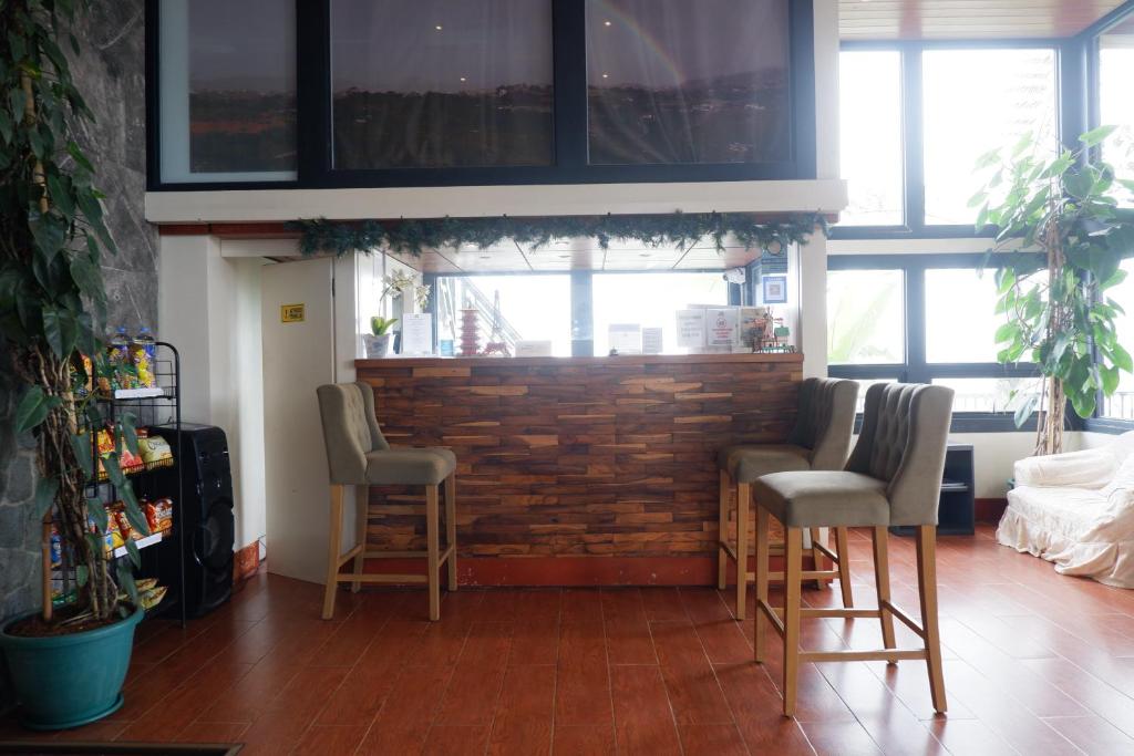 碧瑤的住宿－Sunset View Ridge Residences，一间酒吧,配有四把椅子和砖墙